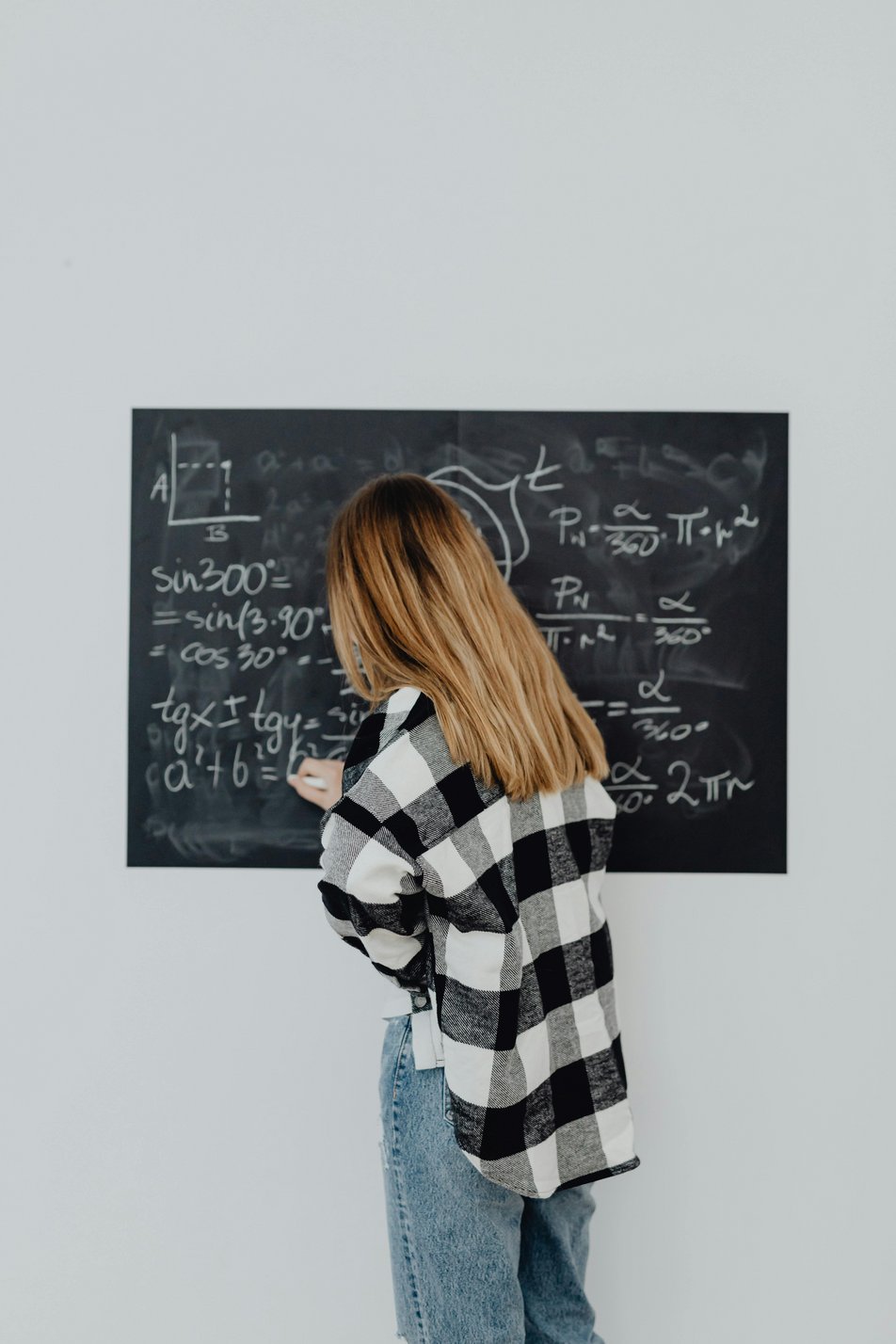 Geometrie: Studentin vor Tafel mit geometrischen Formeln