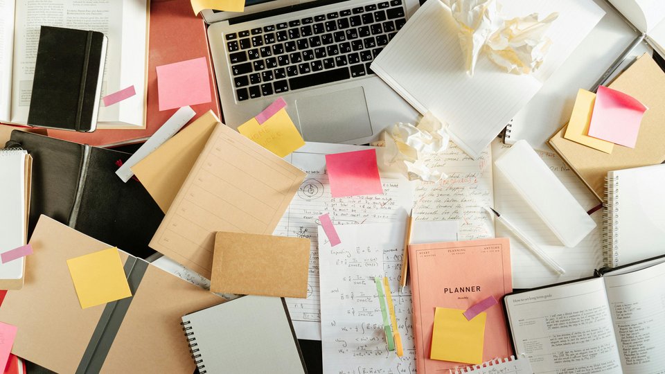 viel Papier und Notizen rund um ein Notebook