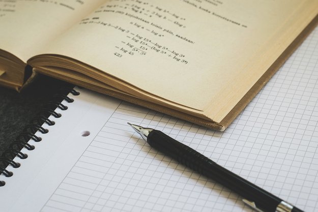 Algebra: Stift, Papier, Buch mit Formeln